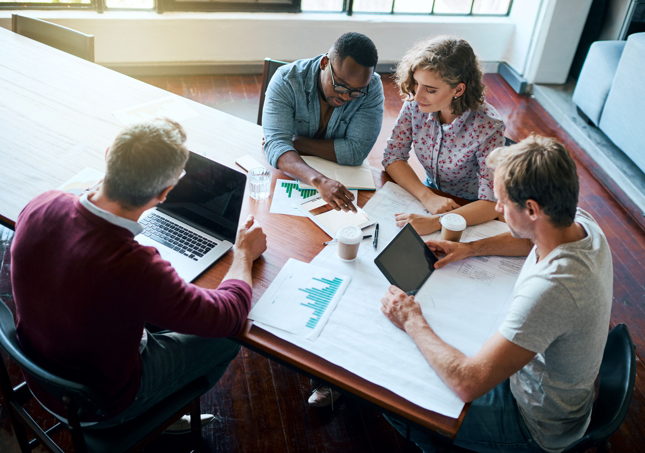A group of people working around a table A group of people working around a table